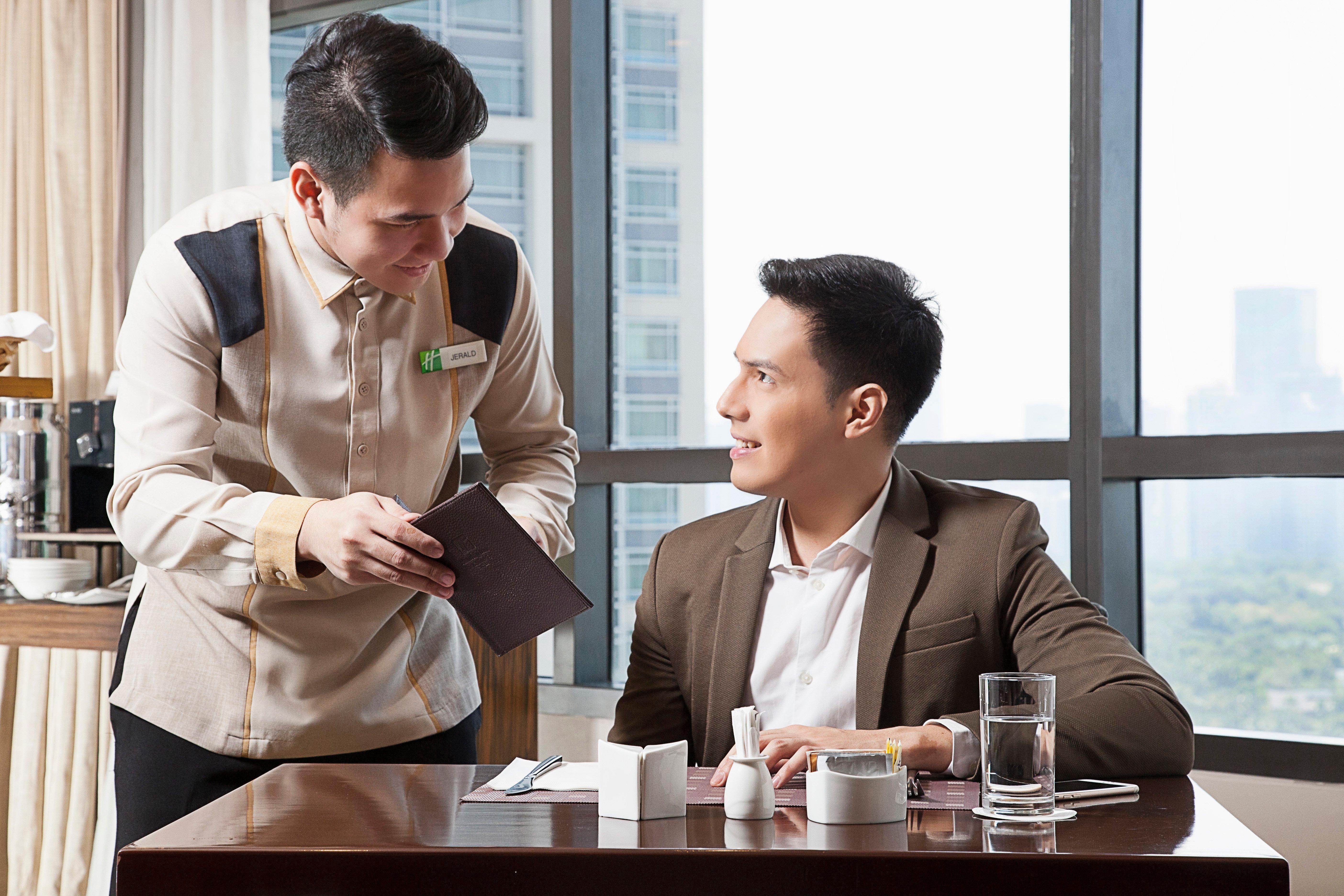 Holiday Inn & Suites Makati By Ihg Makati City Buitenkant foto A butler serving a guest